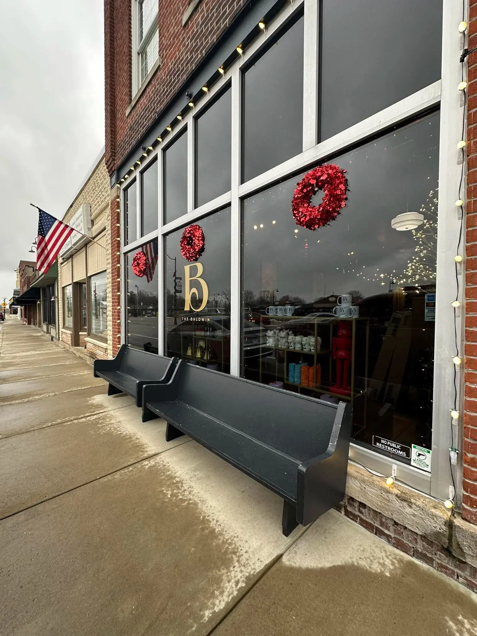Black bench seating on the sidewalk outside The Bar on Baldwin in downtown Bargersville, Indiana